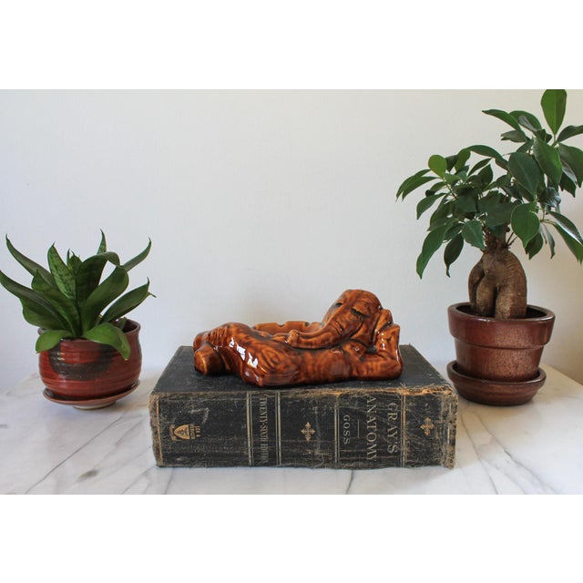 Vintage brown reclining ceramic elephant ashtray. No makers mark. Minor age wear. No chips or cracks.