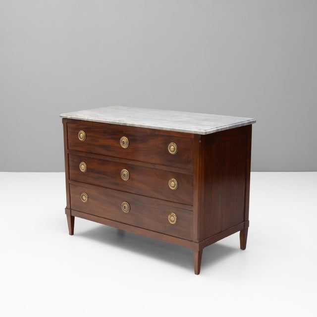 French mahogany three drawer commode on tapered legs with original brass fittings and marble top. Circa 1850.