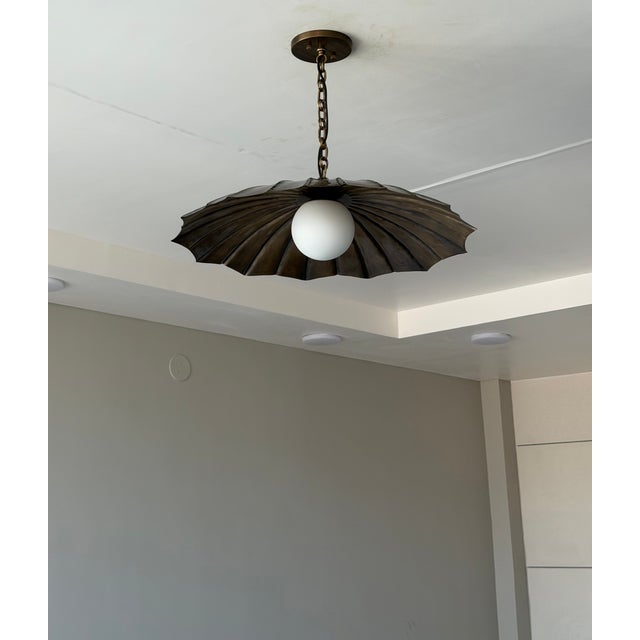 Add a warm, artistic statement to your space with this handmade black antique brass pendant light. Featuring sculptural...