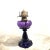 This late 19th-century oil lamp features a rich amethyst glass body and a Queen Ann brass burner marked “Scovill Mfg Co....