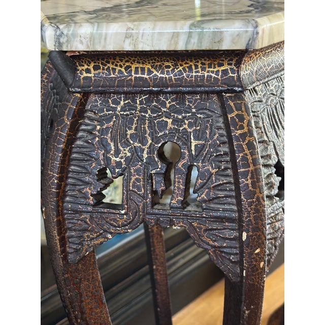 A striking and rare pair of early 20th century hexagonal pedestals featuring a beautifully distressed black or dark brown...