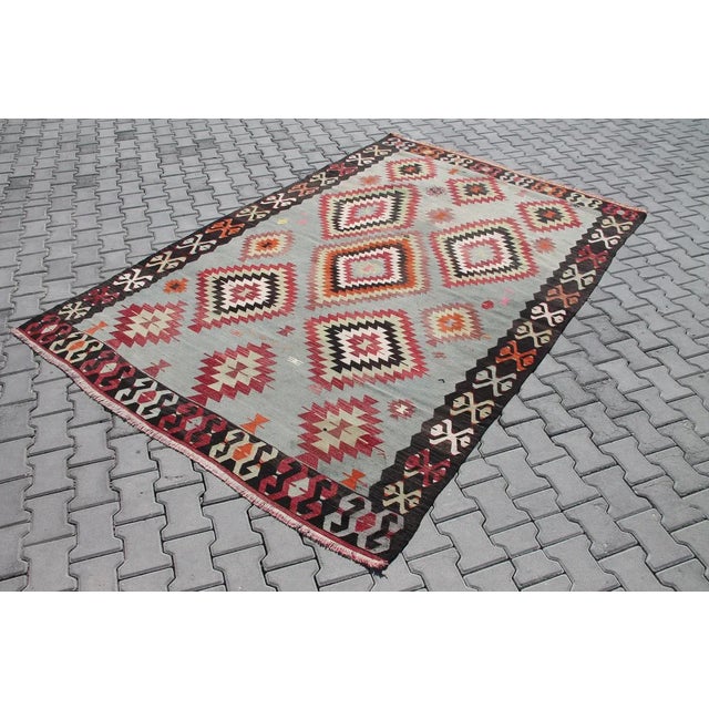 This beautiful, traditional vintage, flatweaved Turkish kilim rug is approximately 60 years old. It is handmade of very...