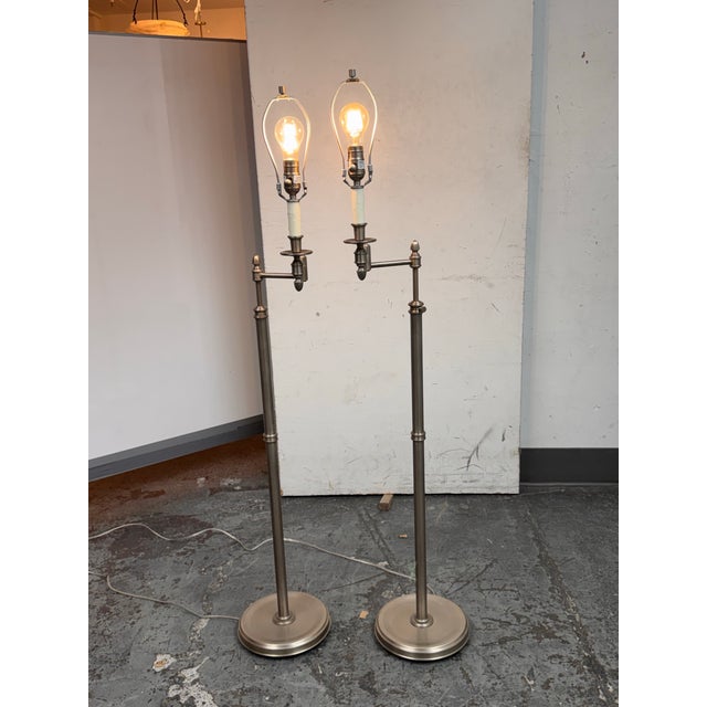 Design Plus Gallery presents a Pair of Transitional Brushed Nickel Swing Arm Floor Lamps. This matching pair showcases...