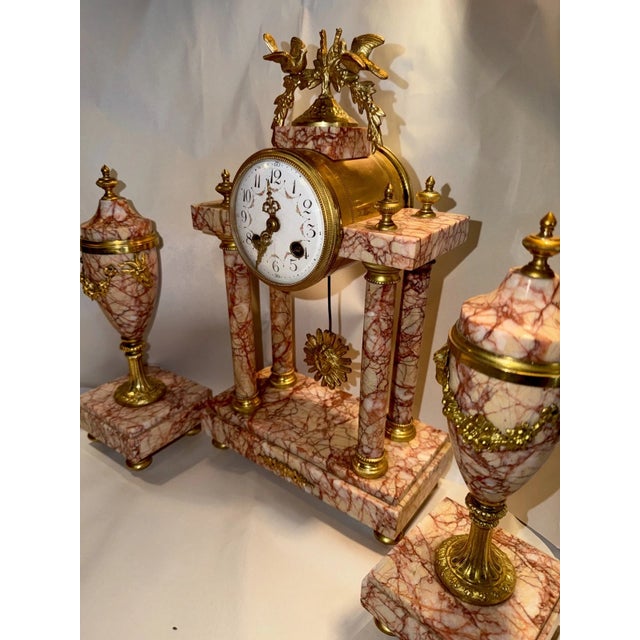This listing is for a nice antique French mantel clock garniture. This is a 3 piece set with clock and matching urn form...