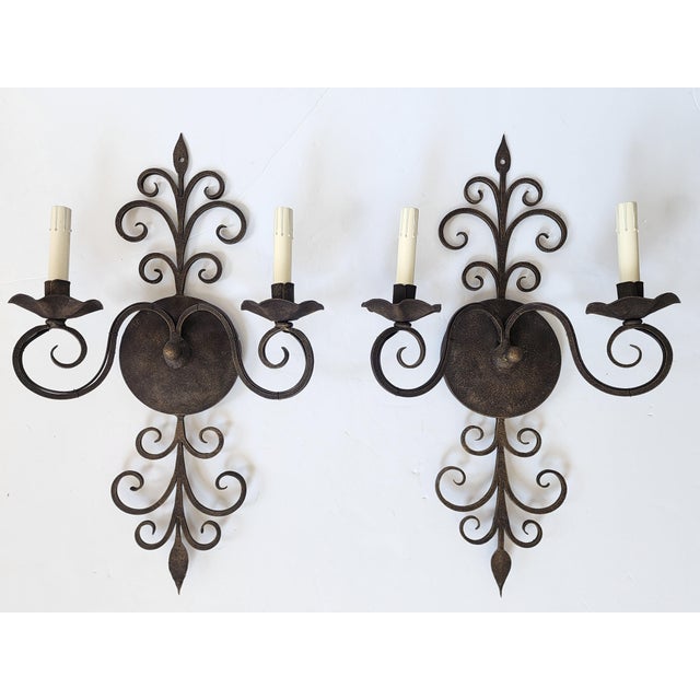 Vintage dark bronze finish wrought iron wall sconces with beautifully cascading motifs. The handcrafted pair of lights...