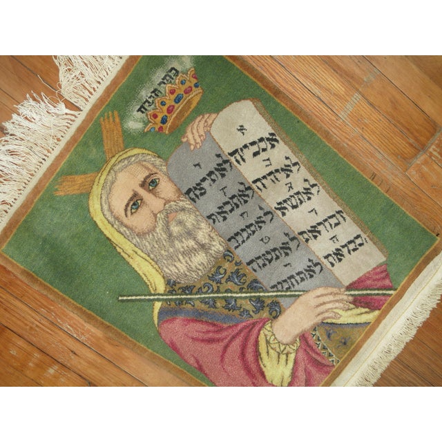 A 3rd quarter of the 20th century Persian Tabriz Rug with Moses holding the 10 commandments on a green background Details...