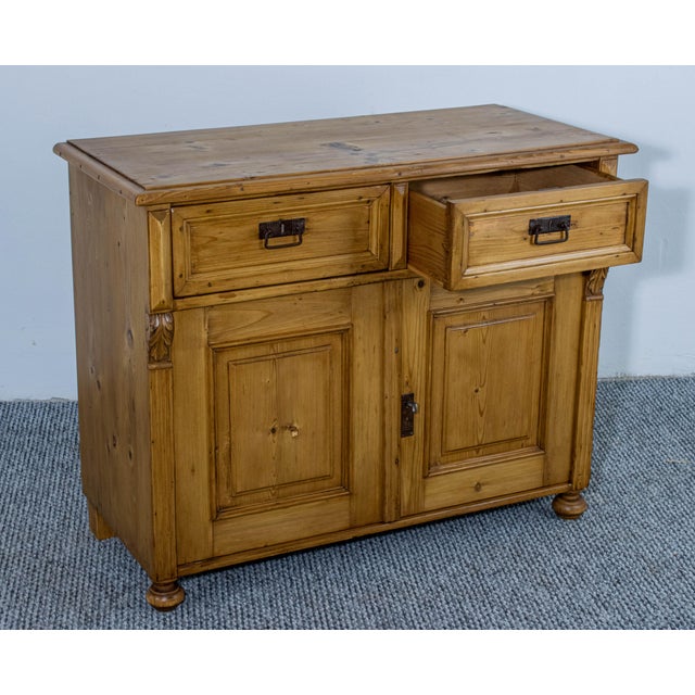 This charming 19th-century dresser base features two drawers and two paneled cupboard doors, offering practical storage in...