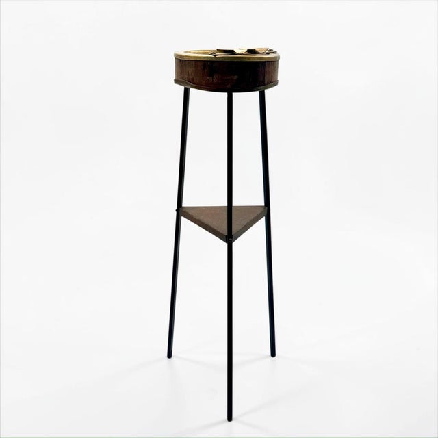 Sculptural mid-20th-century standing ashtray combining brass, wood and black painted metal. The unusually slender three-...
