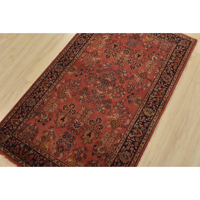 A traditional Sarouk rug hand-knotted with an all-wool pile on a cotton foundation. This finely woven oriental rug...