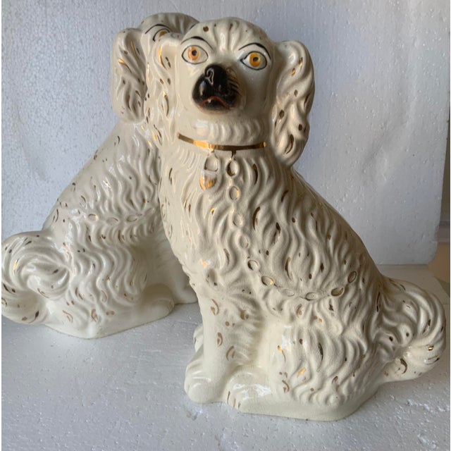 Pair of Staffordshire Spaniels one posed right and one posed left; glazed in a white finish with gold accents and collar;...