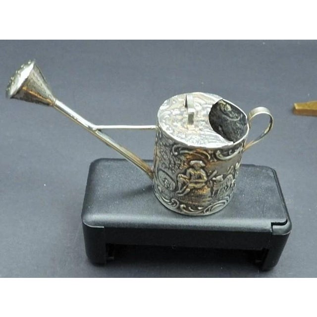 This marvelous antique miniature watering can is created in gorgeous Continental silver with pastoral scenes on each side....