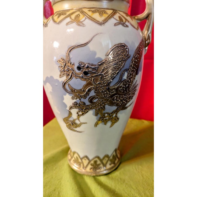 A striking mid‑century ceramic vase showcasing an intricately rendered dragon in raised moriage relief, highlighted with...