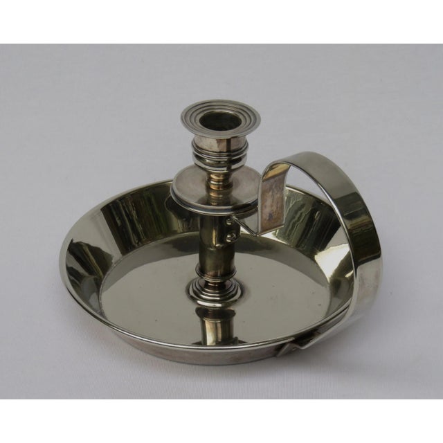 A fancy candle holder, silver plated, from the time of art nouveau. It is marked at the bottom of the spout with: Made in...