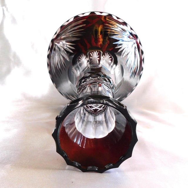 This is a red, cut to clear, decanter with no stopper. The bottle has a wide base and narrow neck. The decanter measures...