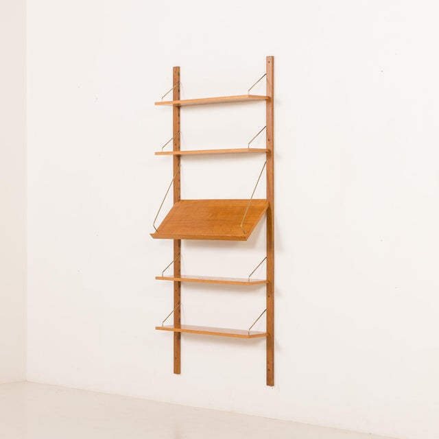 Vintage fully modular oak shelving system unit from Denmark, suspended on solid wood rails with brass hangers. The overall...