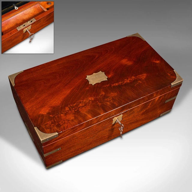This is an antique officer’s campaign correspondence box. An English, flame mahogany and leather writing case, dating to...