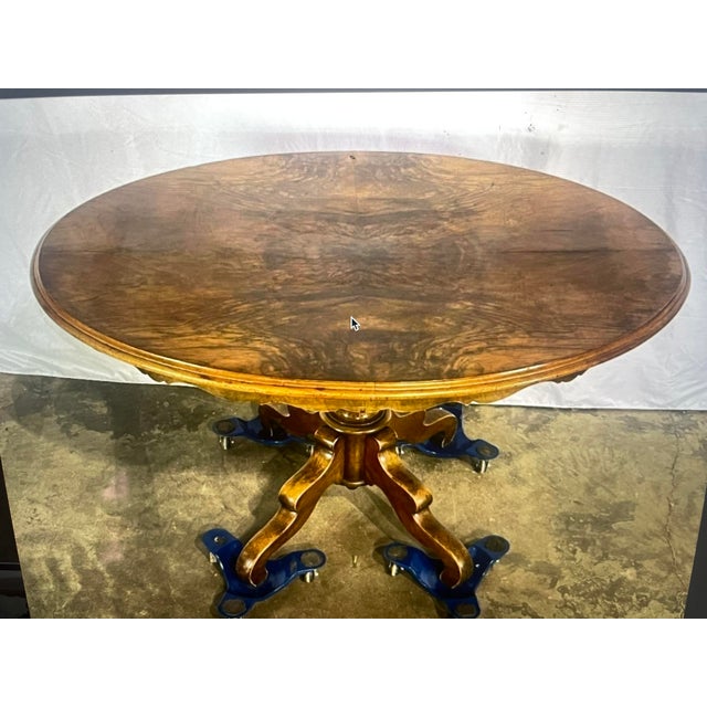 Antique oval pedestal/center table featuring a beautifully crafted central column and an ornately shaped base with four...