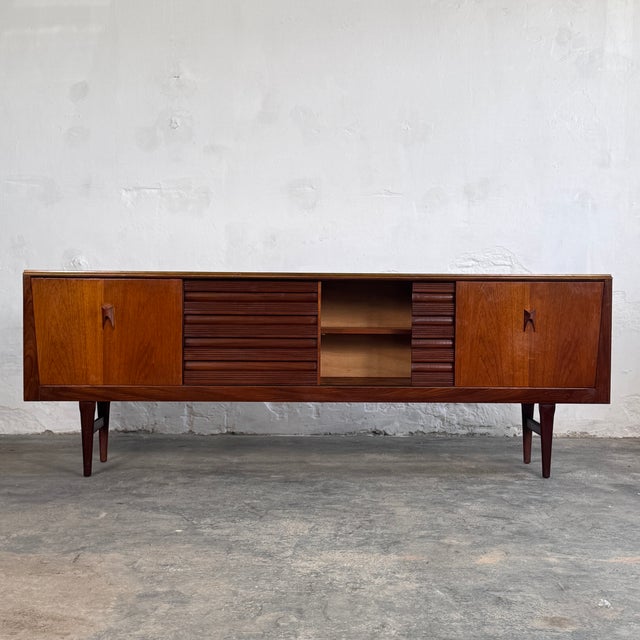 This impressive long sideboard is a quintessential piece of british mid-century furniture, manufactured by the renowned...