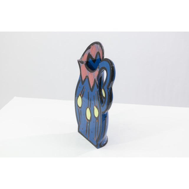 A glazed ceramic flat-form pitcher vase with applied handle and narrow profile by Kathryn Youngs. Signed and dated 1990 on...
