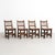 Set of four rustic wood French chairs. Embrace the rustic charm of this set of four mid-century modern rationalist wood...