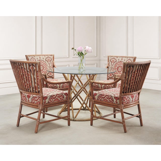 A sophisticated set of four authentic signed rattan upholstered dining armchairs crafted in the California coastal Organic...