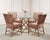 A sophisticated set of four authentic signed rattan upholstered dining armchairs crafted in the California coastal Organic...