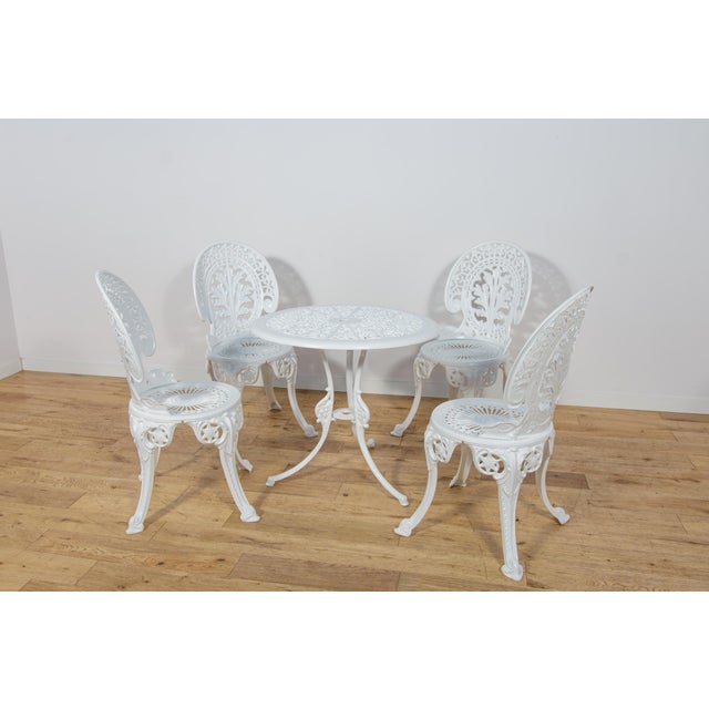 This Victorian-style garden furniture set was manufactured in the United Kingdom during the 1950s. The set consists of a...