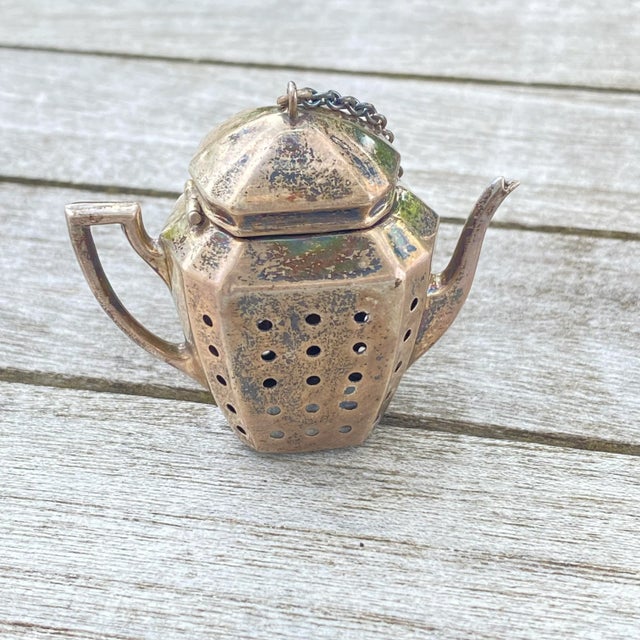 Fantastically fun midcentury sterling silver tea strainer in the shape of a teapot. This beauty is sure to catch the...
