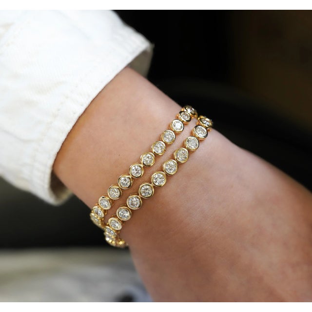 Natural diamond bezel set tennis bracelet in 18K solid yellow gold. Available in 10 carats total with 6.2mm, or 7.83...
