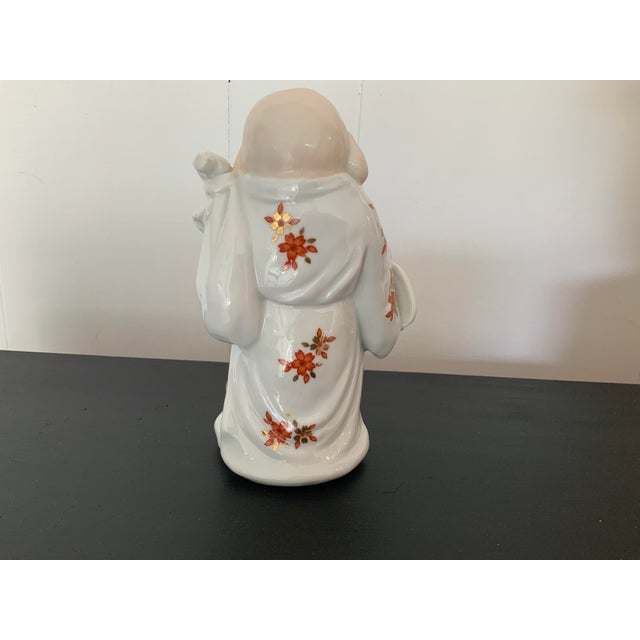A happy Buddah. Hand painted with lovely gold and red/orange flowers. Made in Japan.
