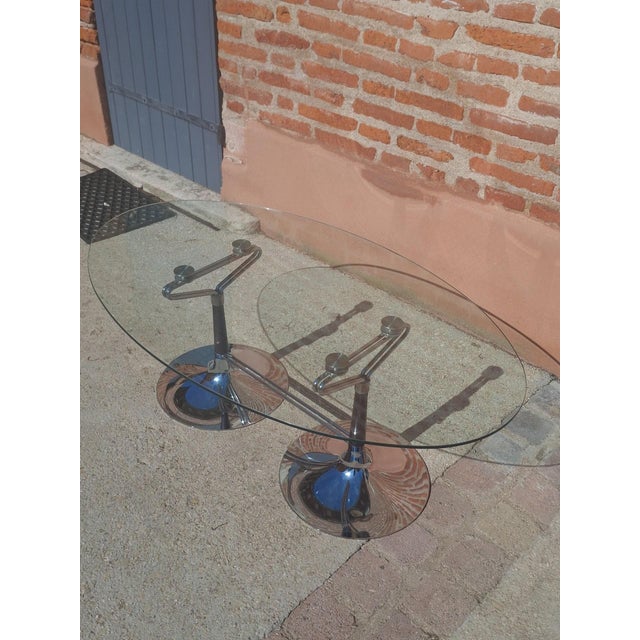 Oval coffee table in the Design style, characteristic of the Space Age aesthetic of the 1970s. The thick, clear oval glass...