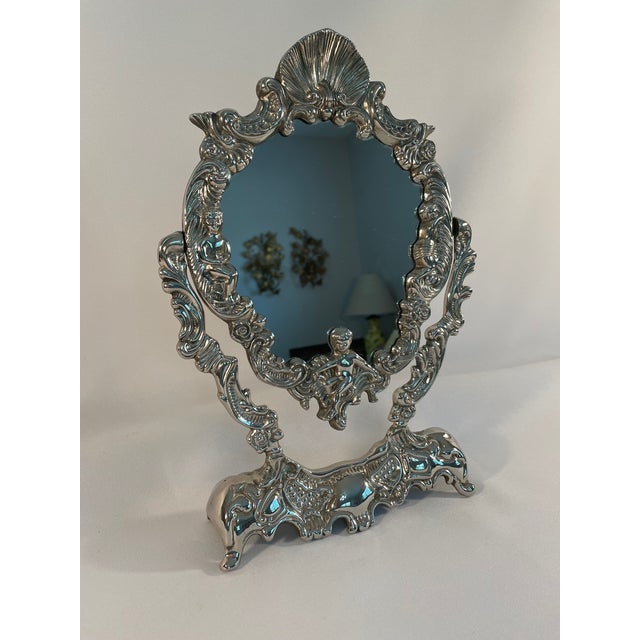 A beautiful Silverplated French Rocco Style Swivel Vanity or Tabletop Mirror. Circa Mid to Late 20th Century. This...