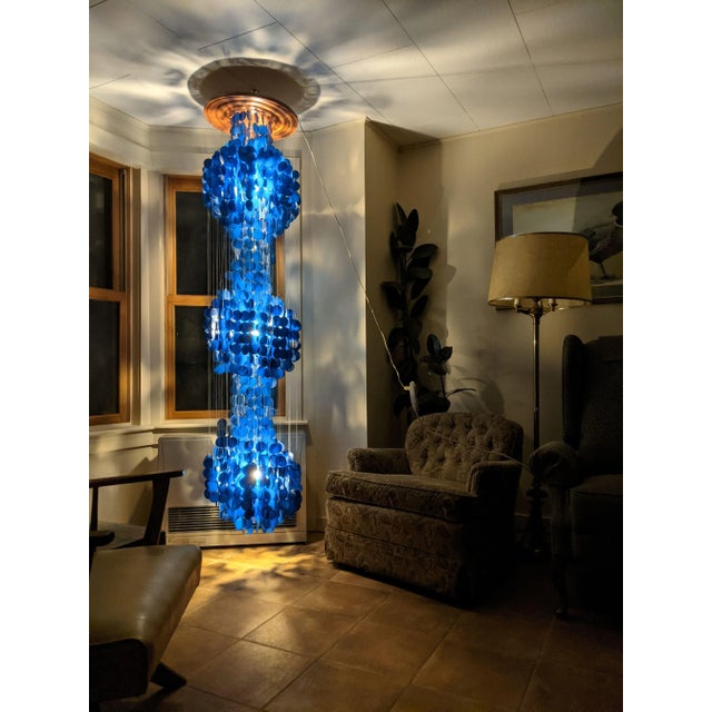 Beautiful blue capiz shell three tier chandelier The shells are suspended from a wood base and overall measures 16" x 16"...