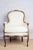 An antique Bergère chair, c. 1820, French. Featuring enclosed arms with a loose seat cushion and upholstered and trimmed...