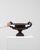 This urn carries genuine presence, its dark bronze/black cast metal, scrolled handles, larger immediately setting the tone...