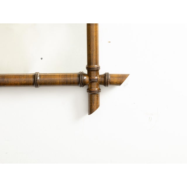 A French rectangular faux-bamboo walnut mirror from the early 20th century, with brown patina. Created in France during...