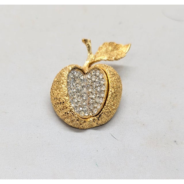 1950s goldtone textured apple with leaf with a bite taken out of it, with the inside of the apple comprised of pavé round...