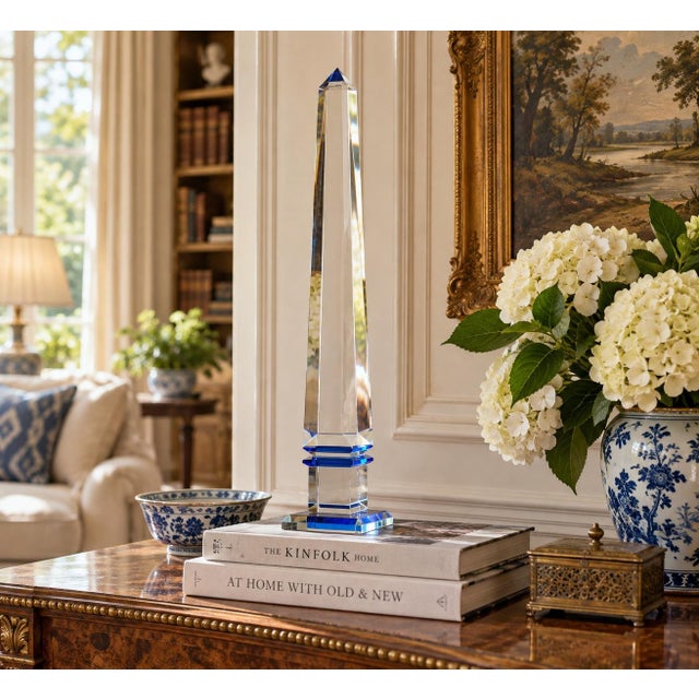 A beautifully proportioned solid crystal obelisk with cobalt blue details. The sculptural silhouette and cobalt detail...