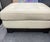 Roche Bobois square ottoman in cream pebbled leather with button tufting and a solid dark wood plinth base. A contemporary...