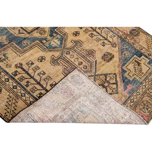 Beautiful vintage Persian distressed hand-knotted wool rug with a tan color field. This piece has blue, pink and brown...