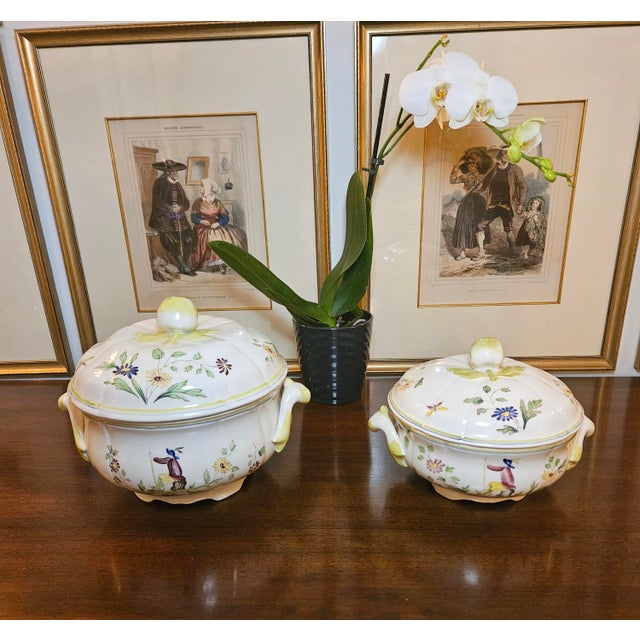 These vintage Longchamp Moustiers hand-painted French faience lidded tureens feature a central figure in traditional...