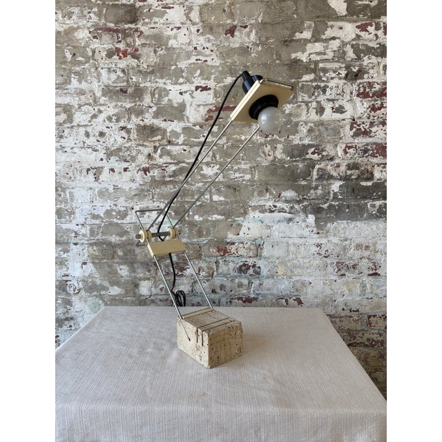 A striking vintage table lamp sourced in Parma, Italy, featuring an architectural travertine stone base paired with an...