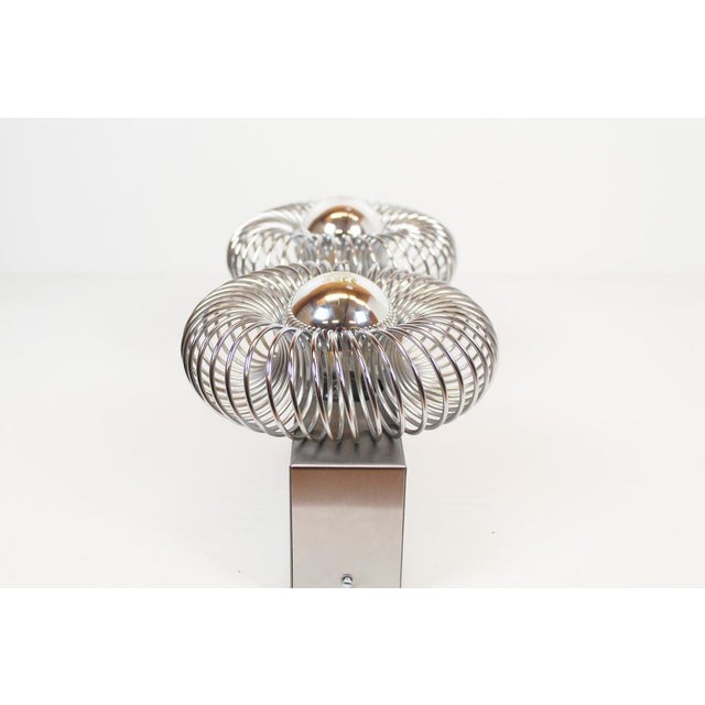 Well-known 1980s wall lamp by Philippe Rougier for Oxar. Aluminum frame with two E27 light points. Two metal springs are...
