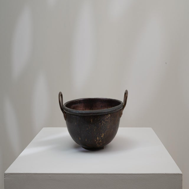 This 19th Century Belgian copper pot is a beautifully aged utilitarian vessel that showcases the rich patina and wear...