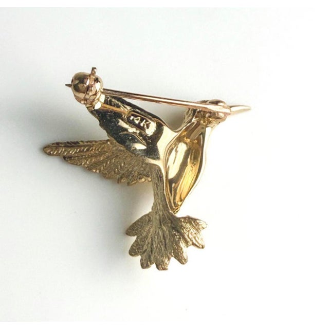 This exquisite 14K yellow gold hummingbird brooch is a refined celebration of artistry and symbolism. Weighing 3.3 grams...