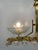 Art deco-style pendant lamp featuring a gold-finish brass frame and an elegant symmetrical composition. It features two...