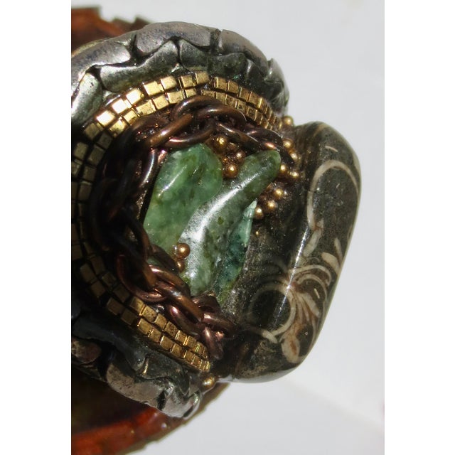 Wendy Gell 1986 cuff built with an assembly of jade medallions, Black Shell fossil stones, and Jade pebbles bordered by a...