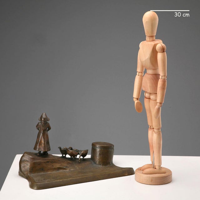 Bronze inkwell with a sculpture of a young Dutch girl walking with geese. A stump-shaped cruet holder. Glass cruet. This...