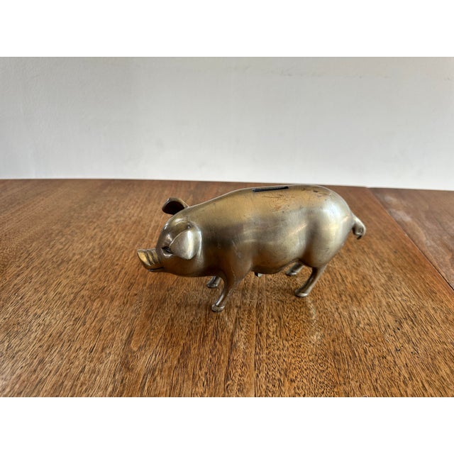 Charming solid brass piggy bank with a warm golden patina and classic mid-century shape. Features a coin slot on top and a...