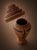 A tall, handcrafted woven basket with a fitted lid is shown in a clean, studio-style presentation. The piece has an...
